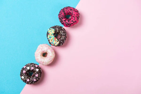 Різнокольорові Пончики Поспіль Мінімалізм Синьо Рожевому Тлі Вид Зверху — стокове фото