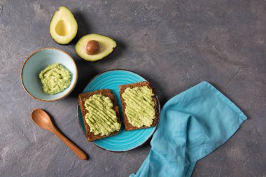 Avokado tostları tam tahıllı ekmek, limonlu avokado püresi, sağlıklı beslenme konsepti, üst görünüm