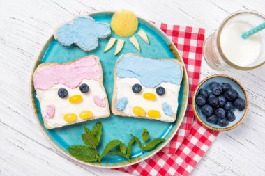 Tabağa serpiştirilmiş şirin penguen tostları, çocuk fikirleri, üst manzara.