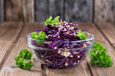 Maydanozlu kırmızı lahana salatası, fındık serpiştirilmiş, ahşap arka plan