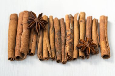 Tarçın çubukları ve anason yıldızları beyaz ahşap arka planda