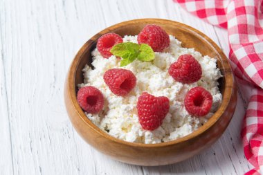 Taze ahududu ve yeşil nane yapraklı süzme peynir, taze böğürtlen, sağlıklı kahvaltı kavramı.