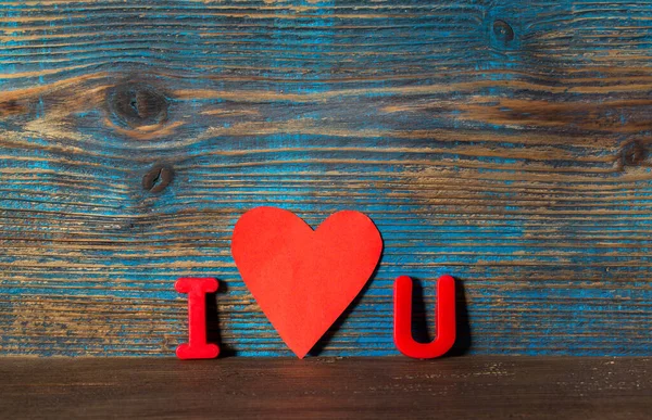 Sevgililer Günü arkaplanı, mıknatıs harfleri I ve U ve kırmızı kalp arasında tahta bir arka plan