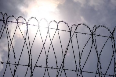 Mavi gökyüzüne karşı dikenli tel
