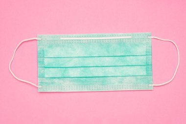 Pembe arka planda tıbbi yüz maskesi. düz yat