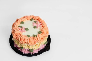 Beyaz arka planda güllerle süslenmiş güzel ev yapımı pasta..