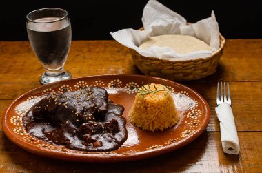 Köstebek, tipik Meksika yemeği. Ahşap masada kil tabakta servis edilir.