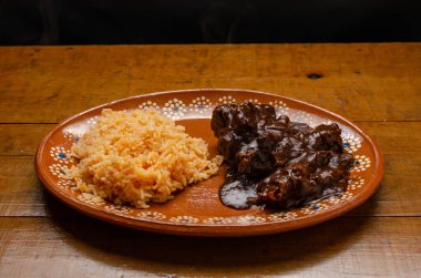 Köstebek, tipik Meksika yemeği. Ahşap masada kil tabakta servis edilir.