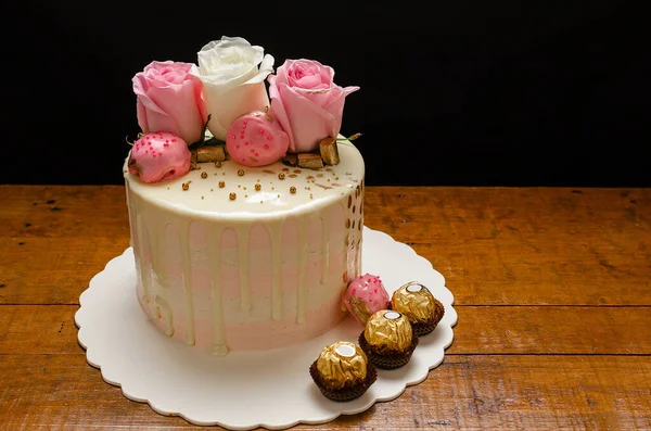 天然のバラやチョコレートで飾られた美しいケーキ 木製のテーブルの上に 自家製 — ストック写真