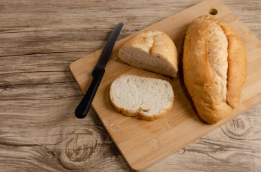 Tahta ve ahşap masada kesilmiş beyaz ekmek..