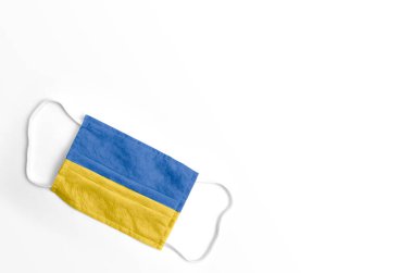 Beyaz arka planda, izole edilmiş Ukrayna bayrağıyla yüz maskesi.