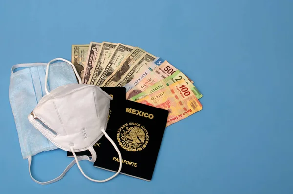 Yüz maskeleri, Meksika pasaportları ve mavi arka planda para..