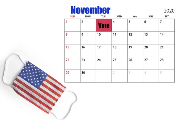 Calendar with marked Election Day and a mask with the American flag. November 3, 2020.