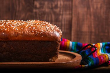 Tahta tepside susam tohumlu Salvador sarısı ekmek.