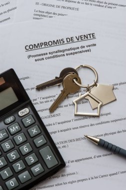 Fransızca satış anlaşması, anahtarlar, hesap makinesi ve kalem. Emlak satın alma konsepti. Fransa