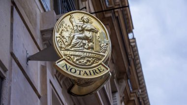 Fransa 'daki bir noter bürosunun ön cephesine Fransız noter tabelası asılmış. Tabelada 