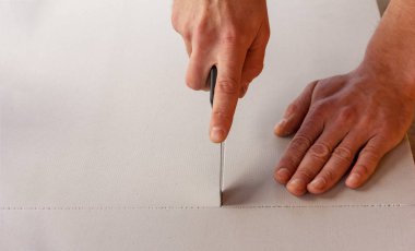 adam ısı yalıtım ve ses geçirmez malzeme bir levha bir ileti örneği bıçakla keser.