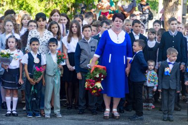Adıge, Rusya Federasyonu - 1 Eylül 2017: buketler çiçek olan çocuklar okulda birinci sınıf öğretmen ve lise öğrencilerinin öğretim yılı ciddi açılışında kayıtlı