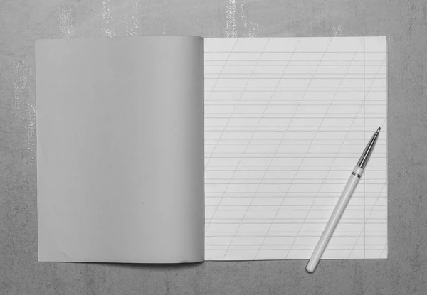 コピー スペースと灰色の背景 平面図 黒と白の写真のボールペンをスペル モックを学習のためのスラッシュが付いた細長い線で学校のノートブックを開く — ストック写真