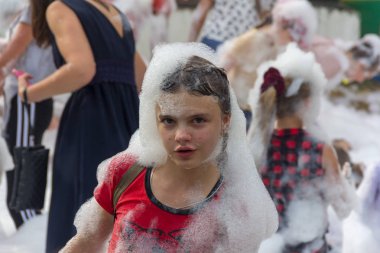 Kamennomostsky, Russia - September 1, 2018: Happy children having fun at a foam party at a holiday town day Kamennomostsky in an autumn park clipart