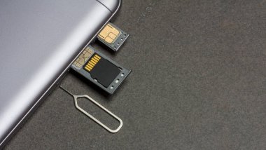 cep telefonu ve nano SIM kartlar, mikro Sd götürmek ve kopya alanı ile gri arka plan üzerinde metal anahtar için açık yuvası