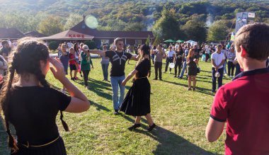 Dakhovskaya, Rusya - 22 Eylül 2018: genç adam ve Kafkasya eteklerine Adygei peynir Festivali çayırda dans kızı