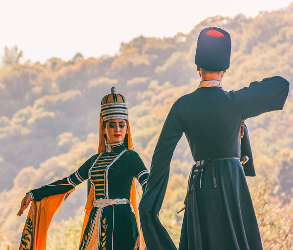 Dakhovskaya, Russia - September 22,  2018: a guy with a girl in traditional Circassian clothes dancing at the festival of Adyghe cheese in the foothills of the Caucasus