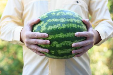 büyük bir karpuz tutan bir adam
