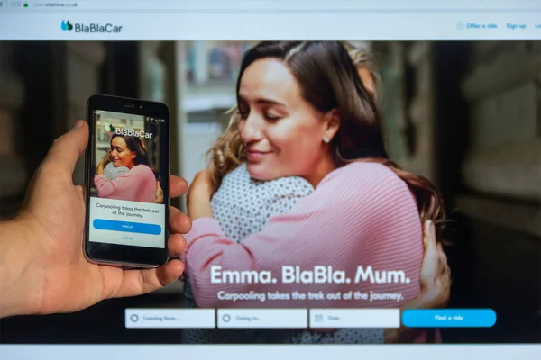 モスクワ ロシア連邦 2018 インターネットのホームページ画面上のモバイル アプリケーション Blablacar Com の男性のスマート フォンに手を背景のモニターに対して — ストック写真