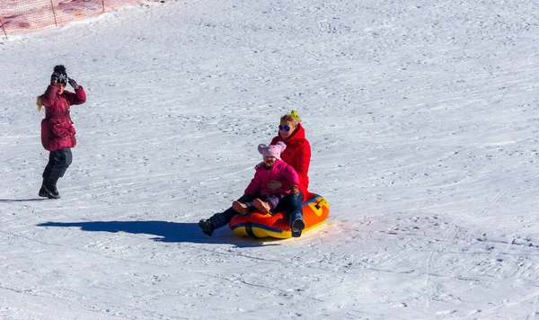 俄罗斯阿迪加 2017年1月23日 一位带着小女儿的年轻母亲在雪坡上骑充气雪橇管道 — 图库照片