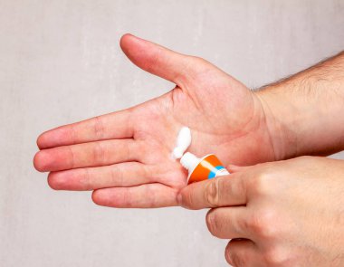 Adam el kremi gri arka plan üzerinde closeup uygulama