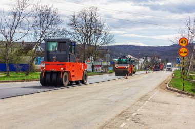 Kamennomostsky, Rusya - 13 Nisan 2019: Köyde otoyolda yeni asfalt serpiştirme asfalt silindirleri