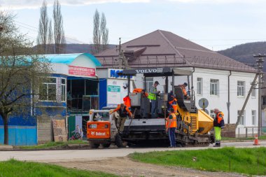 Kamennomostsky, Rusya - 13 Nisan 2019: asfalt paver ile çalışan yol işçilerinden oluşan bir ekip