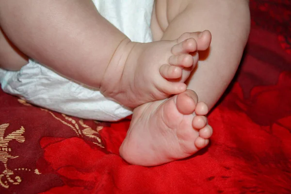 Piernas Una Niña Cuatro Meses Dormida Una Cama Roja —  Fotos de Stock