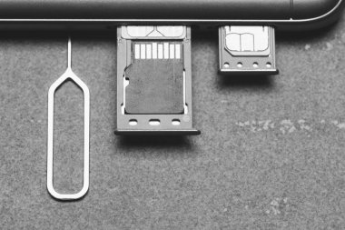 Akıllı telefon açık Sim yuvaları ve kopya alanı ile gri bir arka plan üzerinde mikro Sd bellek, üst görünüm yakın çekim siyah beyaz fotoğraf
