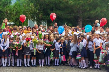 Adygea, Rusya - 1 Eylül 2018: Birinci sınıfa ellerinde çiçek ve balon buketleri ile kayıt yaptıran çocuklar, öğretmenler ve lise öğrencileri okul resmi geçit töreninde
