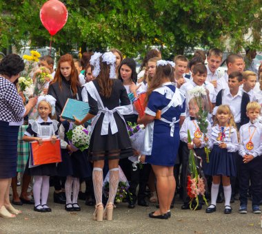 Adygea, Rusya - 1 Eylül 2018: Liseli kızlar bilgi gününde düzenlenen gala töreninde birinci sınıföğrencilerine hediyeler takdim ediyor