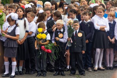 Adygea, Rusya - 1 Eylül 2018: Birinci sınıfa ellerinde çiçek ve balon buketleri ile kayıt yaptıran çocuklar, öğretmenler ve lise öğrencileri okul resmi geçit töreninde