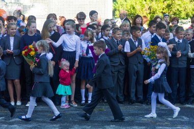 Adygea, Rusya - 1 Eylül 2017: Birinci sınıf öğrencileri bilgi günü lise öğrencilerinin karşısına çiçek buketleri ile 1 Eylül