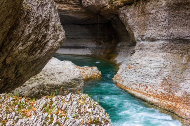 bir taş geçitte zümrüt renkli su ile dağ nehri