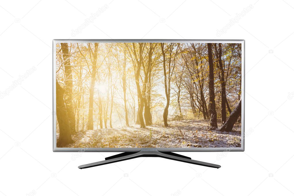 4K monitor or TV with the image of sunrise in the autumn forest with the first snow on the screen isolated on white background