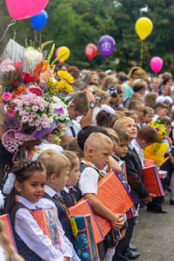 Adygea, Rusya - 1 Eylül 2018: Birinci sınıfa ellerinde çiçek ve balonlarla giren çocuklar, öğretmenler ve lise öğrencileri geçit töreninde