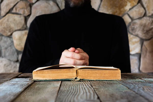 Człowiek Czarnych Ubraniach Przed Otwartą Starą Księgą Biblia Czy Koran — Zdjęcie stockowe
