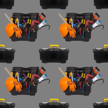 Turuncu bir inşaat koruyucu miğferi ve gri bir grupta izole edilmiş çeşitli el aletleri olan kusursuz plastik alet kutusu.