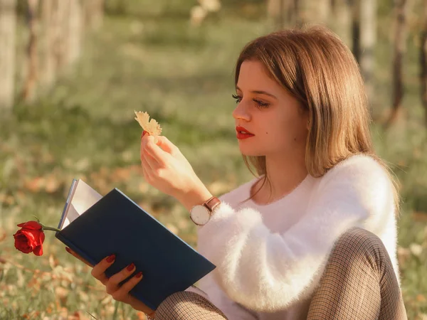 Menina Lendo Livro Sentado Natureza Com Uma Folha Caída Mão — Fotografia de Stock