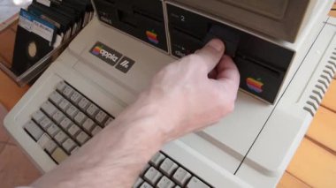 Cisternino, İtalya - 29 Nisan 2018: Yaşlı elma bilgisayar ve el disket iç sonra klavyede yazarak ekleme