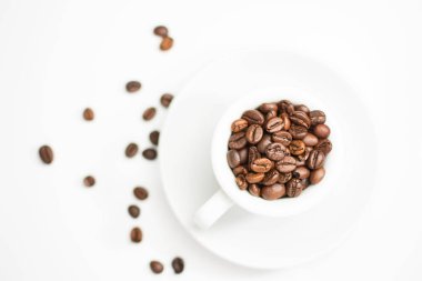 kahve fincanı kavrulmuş kahve çekirdekleri ve beyaz arka plan dolu