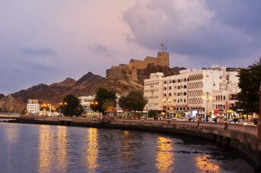 Muscat, Umman - 31 Ekim 2018: Mutrah Fort ve gün batımında Muscat'deki / daki Corniche gezinti