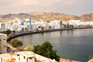 Muscat, Umman - 1 Kasım 2018: Mutrah liman bölgesinde Muscat Camii ile günbatımı ve Corniche kimse ile