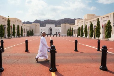 Muscat, Umman - 1 Kasım 2018: Omani adam geleneksel elbise ile Ulusal Müzesi (Umman önünde yürür)